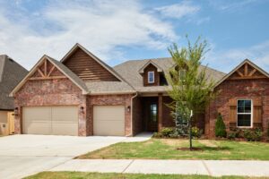 Brick suburban house with three-car garage and Preston floor plan in the Oklahoma City metro area.