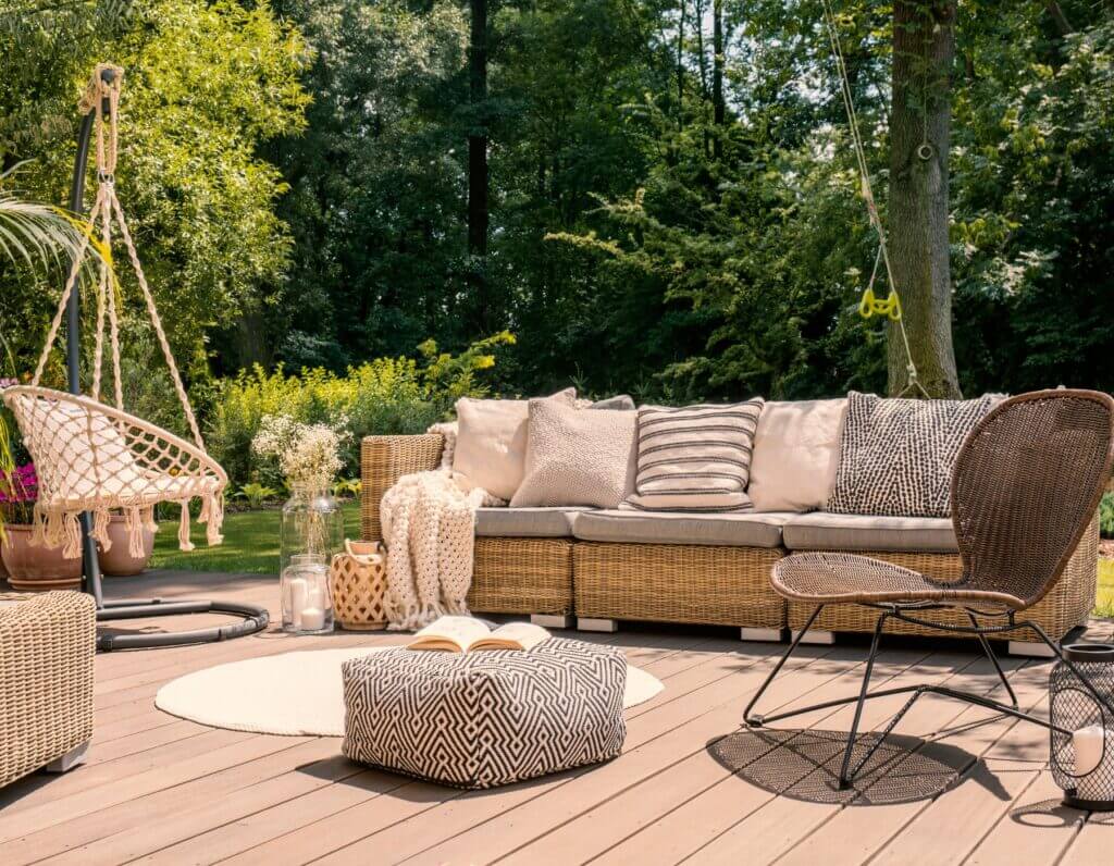 Cozy outdoor patio with wicker sofa, cushions, pouf, and chairs in the Oklahoma City metro area