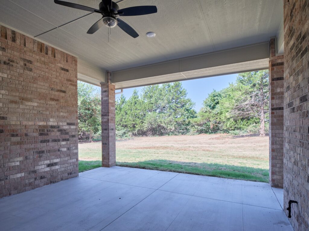Covered brick patio with Ranger floor plan & ceiling fan in the Oklahoma City metro area.