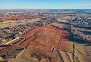 Aerial view of Manning Estates in Oklahoma City, showcasing a large field with dirt patches and scattered trees.