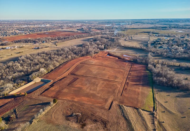 Aerial view of Manning Estates in Oklahoma City, showcasing a large field with dirt patches and scattered trees.