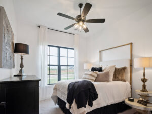 Bedroom with upholstered bed, large window and Lincoln Floor Plan in the Oklahoma City metro area