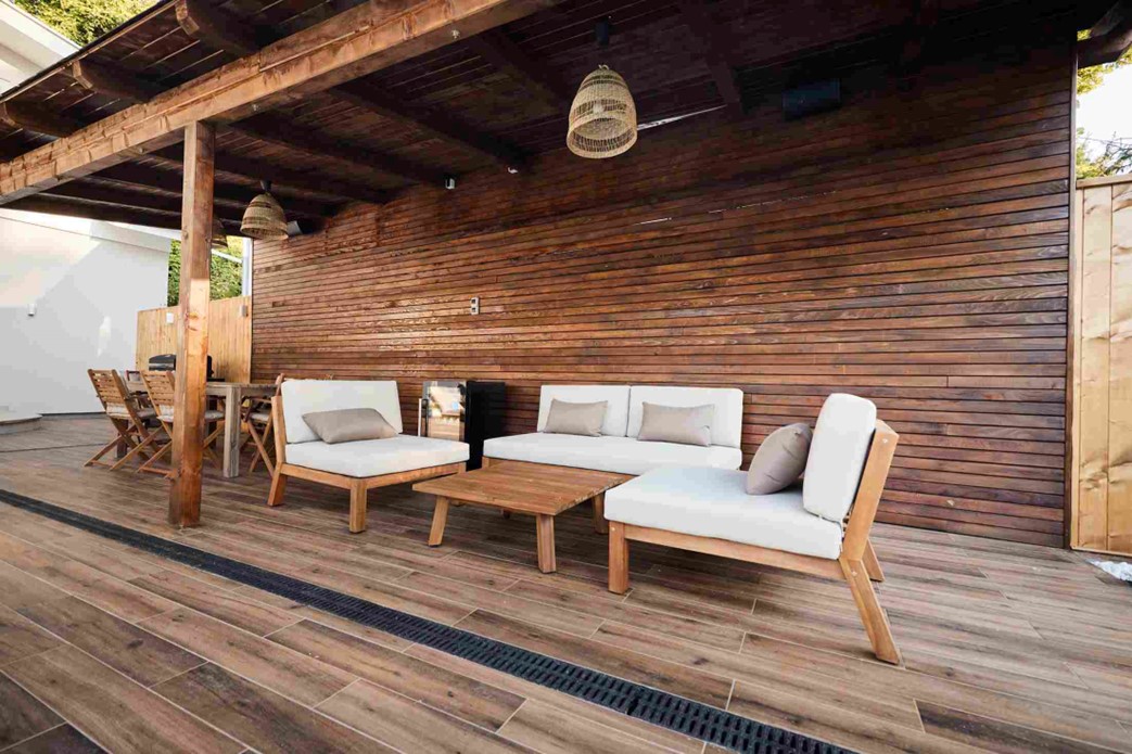 A patio with a wood wall and white couches in OKC metro area
