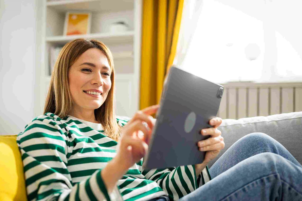 A person sitting on a couch holding a tablet in OKC