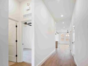 A bright hallway featuring white walls and hardwood flooring in Oklahoma City