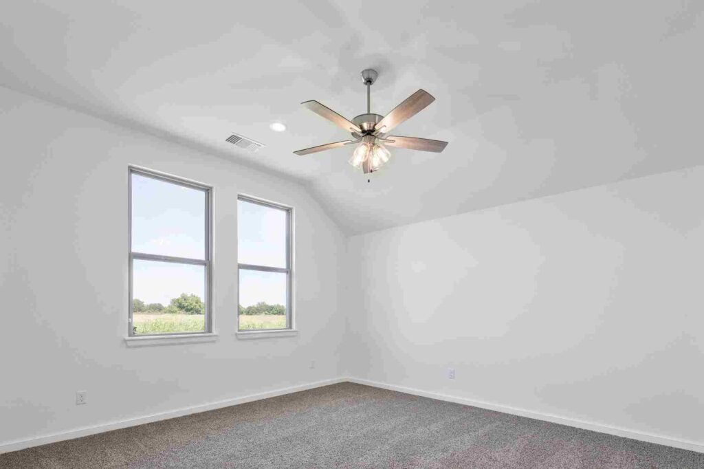 An Oklahoma City room with a ceiling fan and windows, designed for light and airflow
