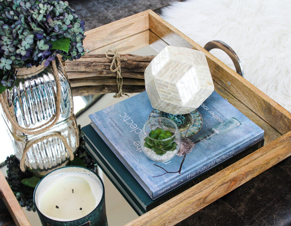 Coffee table of a home with books, a candle, and a flower in the Oklahoma City metro area