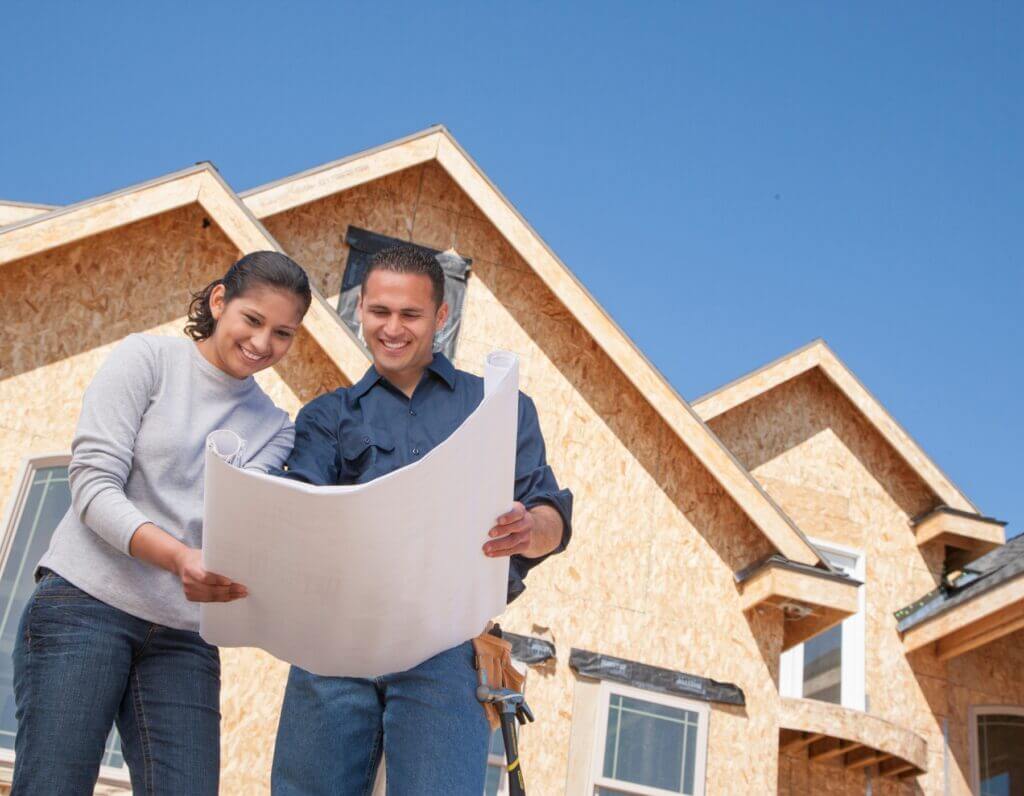 Two people reviewing construction plans of a home on owned land in the Oklahoma City metro area