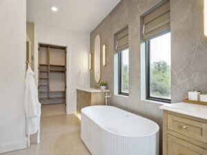 Modern bathroom with freestanding tub, vanity, and windows in Oklahoma City metro area home
